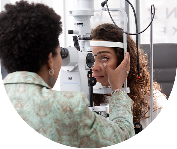 Optometrist onderzoekt oog van vrouw met spleetlamp.
